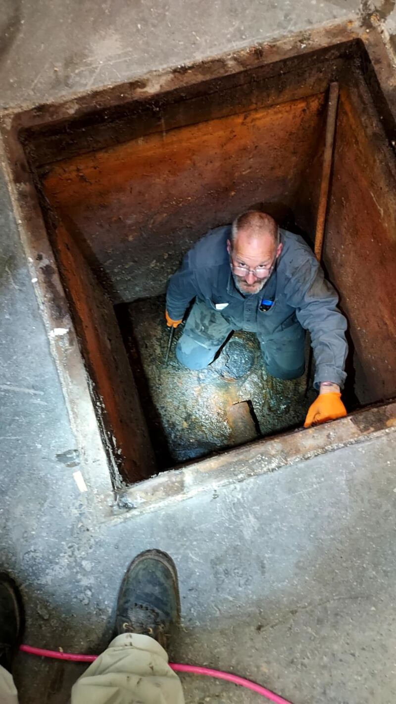 Chris working down in a drain access pit
